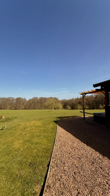 A log cabin and veranda overlooking open fields at Forest View Retreat near Bewdley